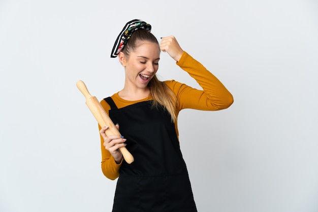 Jeune femme lituanienne tenant un rouleau à pâtisserie isolé