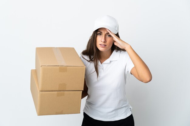 Jeune femme de livraison sur fond blanc isolé regardant loin avec la main pour regarder quelque chose