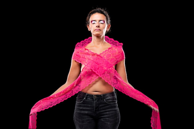 Jeune femme avec un long tissu rose, représentant le symbole et lutte contre la sensibilisation au cancer du sein.