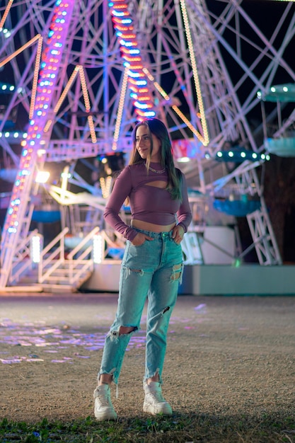 Jeune femme avec les lumières d'une grande roue en arrière-plan