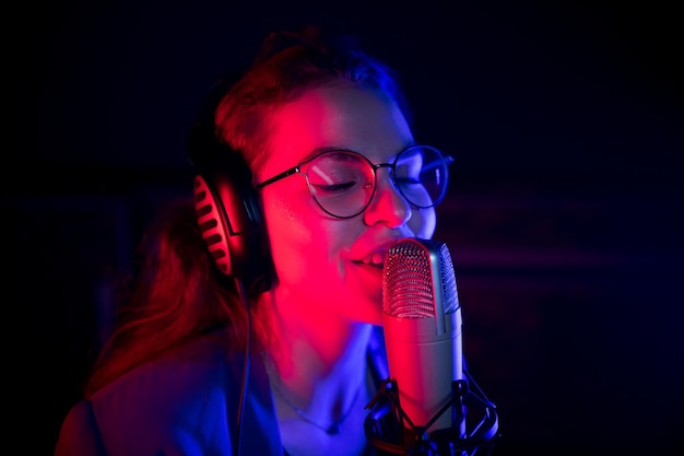 Une jeune femme à lunettes chantant au micro