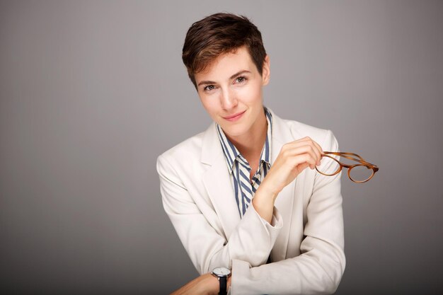 jeune femme avec des lunettes sur fond gris