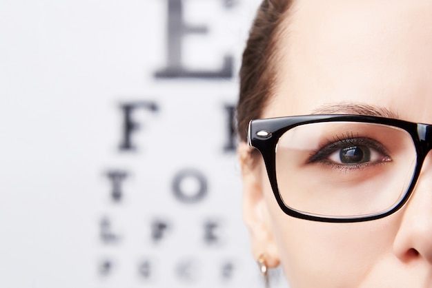 Jeune femme à lunettes sur le fond d&#39;une table pour la vision.