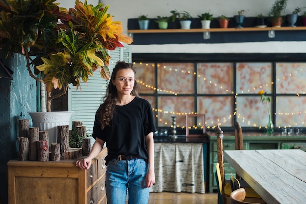 jeune femme à lunettes posant dans son studio de design vintage