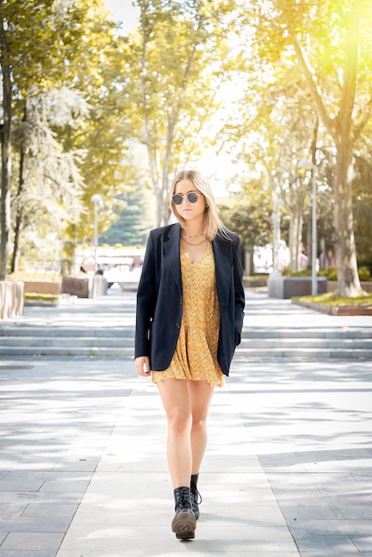 Jeune femme avec des lunettes de soleil marchant dans la rue