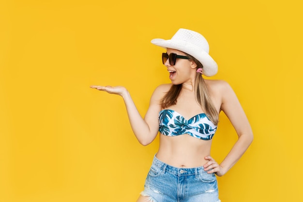 Une jeune femme à lunettes de soleil tient sa main démontrant un espace de copie vide pour les publicités promotionnelles du produit