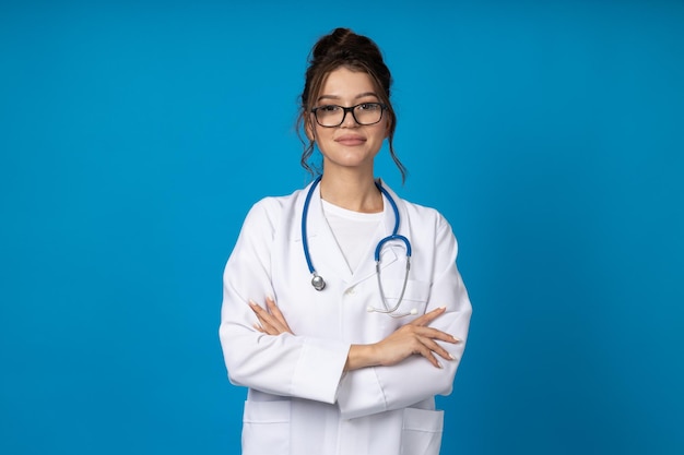 Jeune femme en lunettes avec un stéthoscope sur fond bleu