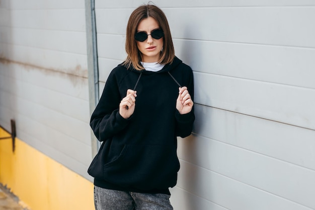 Jeune femme à lunettes et sweat à capuche noir