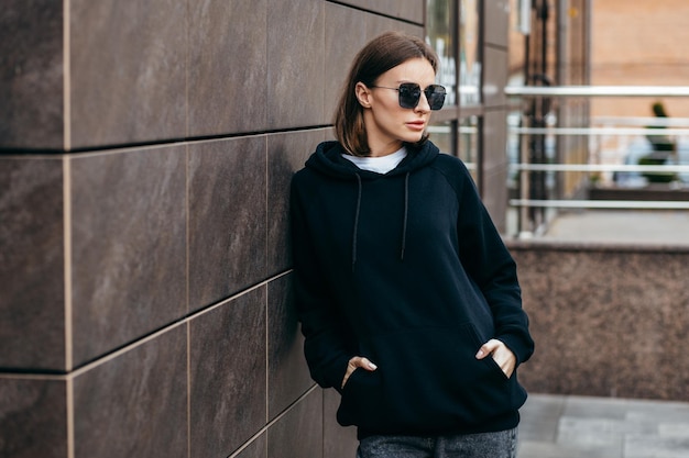 Jeune femme à lunettes et sweat à capuche noir