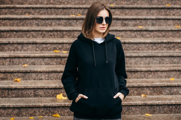 Jeune femme à lunettes et sweat à capuche noir