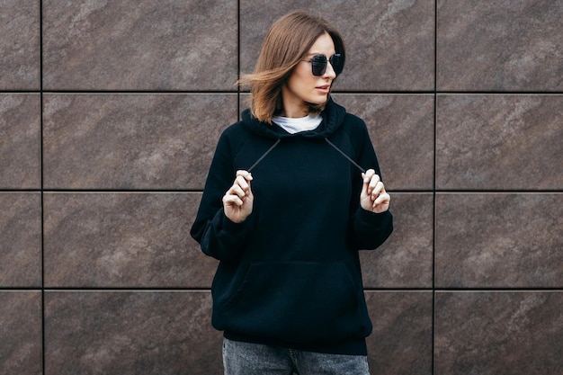 Jeune femme à lunettes et sweat à capuche noir