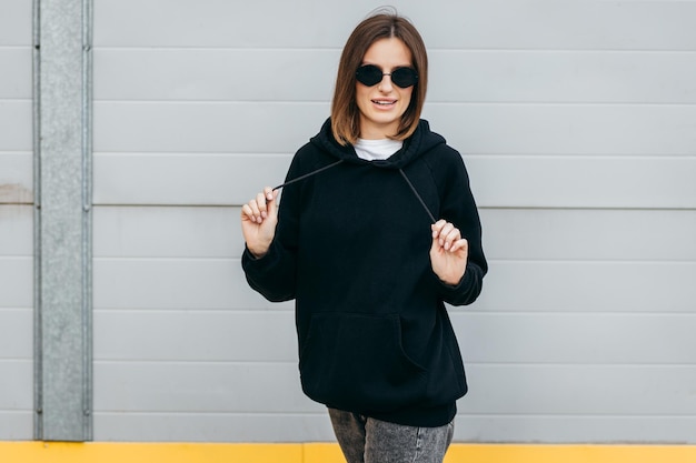 Jeune femme à lunettes et sweat à capuche noir