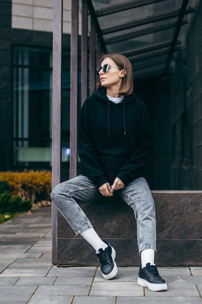 Jeune femme à lunettes et sweat à capuche noir