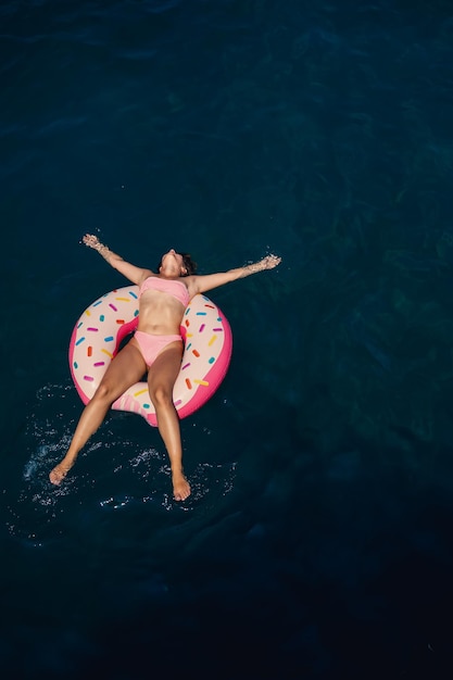 Jeune Femme En Maillot De Bain Nage Sur Un Anneau Gonflable Dans La Mer Concept De Vacances D'été