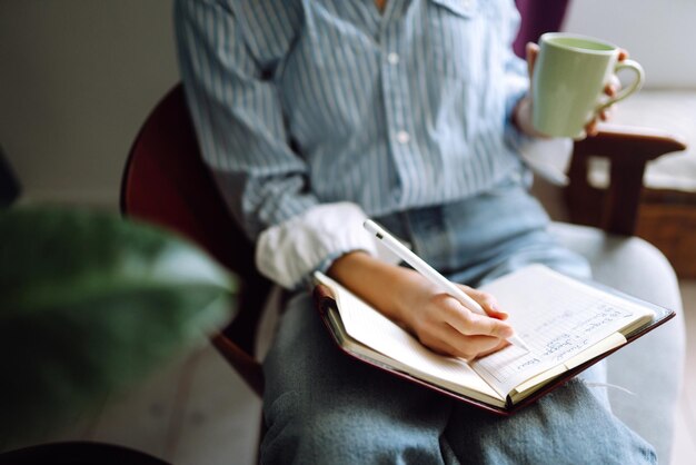 Jeune femme à la maison écrivant et travaillant avec Notebook. Le pigiste travaille et prend des notes.