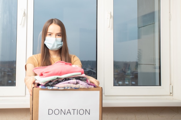 Une jeune femme à la maison ouvre une boîte à colis