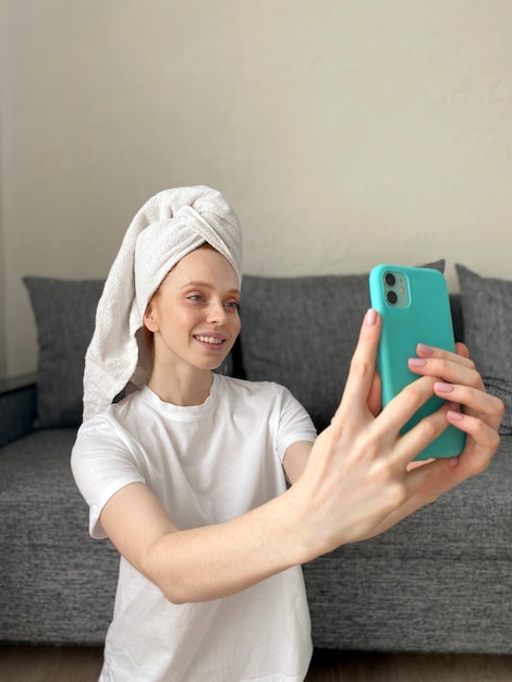 Jeune femme à la maison avec une serviette sur la tête