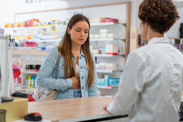 Jeune femme avec un mal de ventre dans une pharmacie