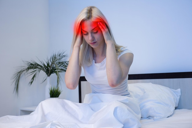 Une jeune femme malade avec une main sur la tête pour une douleur à la tête souffrant de migraine