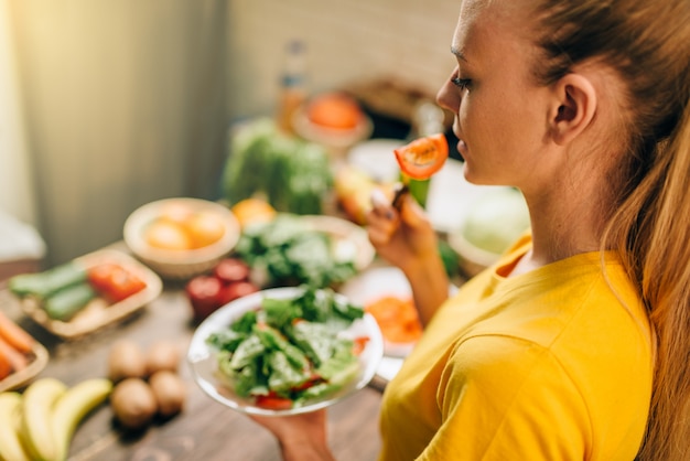 Jeune femme mangeant des aliments sains et écologiques