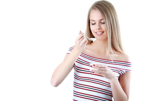 Jeune femme mangeant du yaourt comme petit-déjeuner ou collation