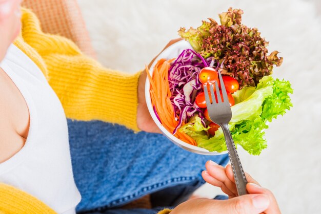 Jeune femme mangeant des épinards végétariens frais repas salade dans un bol