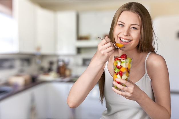 Jeune femme mangeant des fruits en verre