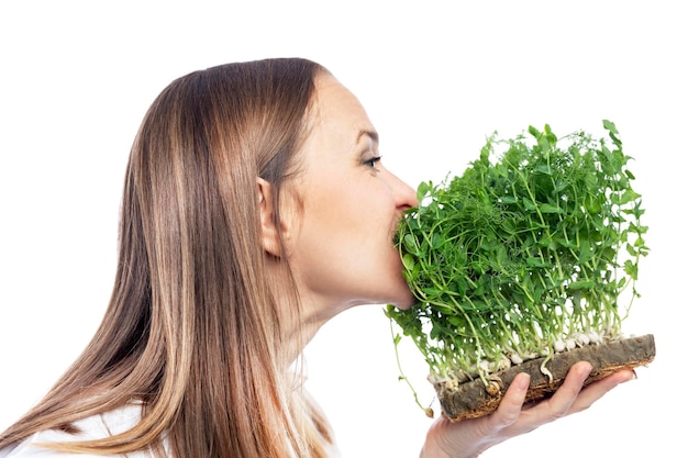 Jeune femme mangeant des microgreens de pois Eco food et vitamines Isolé sur fond blanc Vue latérale
