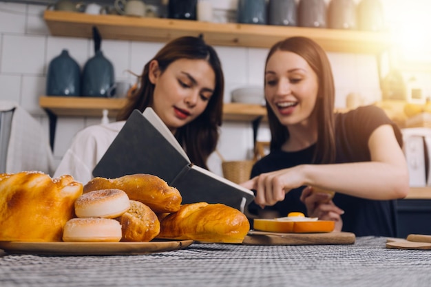 Jeune femme mangeant de la pizza et riant assise avec ses amis dans un restaurant Groupe d'amis profitant de la nourriture et des boissons au café