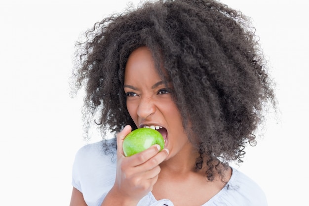 Jeune femme mangeant une pomme verte