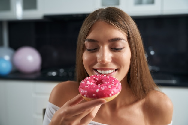 Jeune femme mangeant savoureux tout en célébrant son anniversaire à la maison