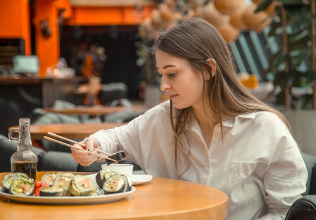 Jeune, femme, manger, apprécier, frais, sushi