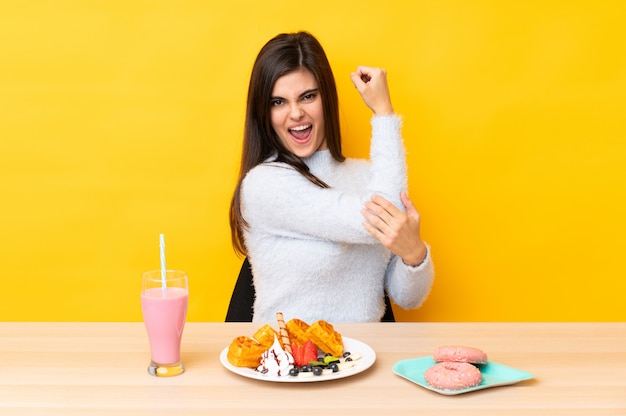 Jeune, femme, manger, gaufres, Milkshake, table, mur, jaune, confection, fort, geste