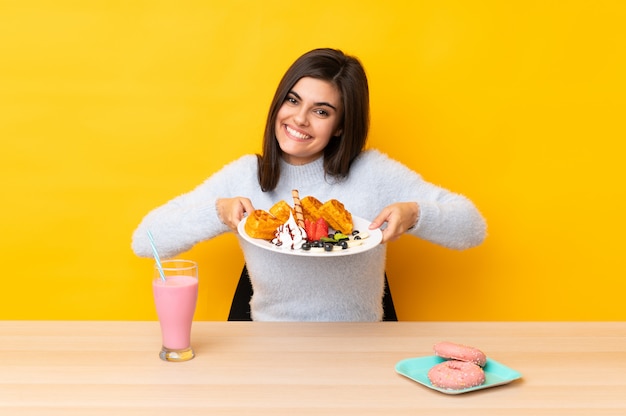 Jeune, femme, manger, gaufres, Milkshake, table