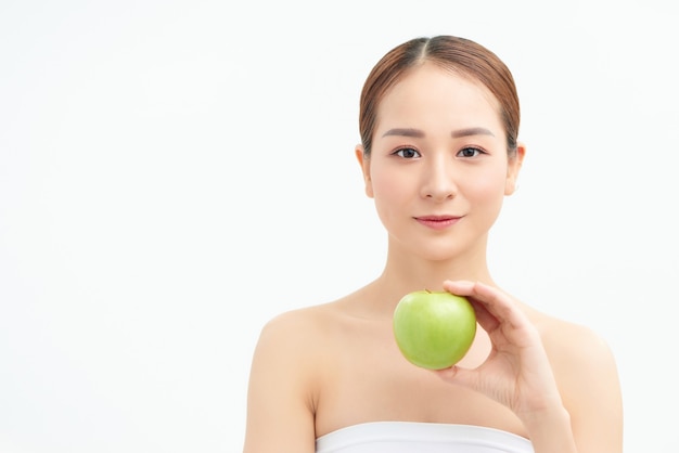 Jeune femme, manger, pomme verte, isolé, sur, mur blanc