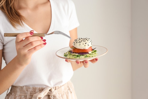 Jeune femme, manger, savoureux, salade, sur, lumière