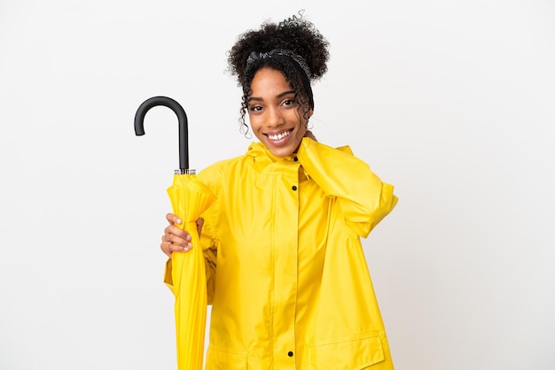 Jeune femme avec manteau imperméable et parapluie isolé sur fond blanc en riant