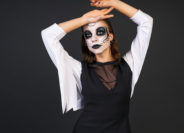 jeune femme avec un maquillage de vampire gothique sur la fête d'Halloween sur fond noir