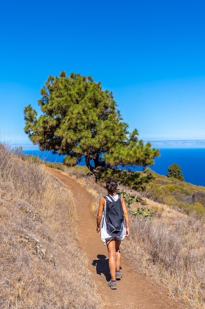 Une jeune femme marchant sur le chemin de Las Tricias dans la ville de Garafia dans le nord de l'île de La Palma, Îles Canaries