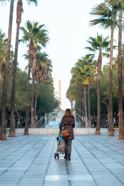 Une jeune femme marchant à côté des palmiers dans la rue Belen de la Rambla de Almeria, Andalousie. Espagne. Costa del sol en mer méditerranée