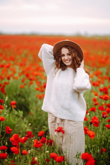 Jeune femme marchant dans un champ de coquelicots incroyable Vacances nature détente et style de vie