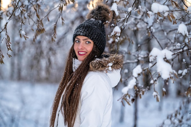 Jeune femme marchant dans la journée d'hiver enneigée fond de paysage de forêt d'hiver en plein air