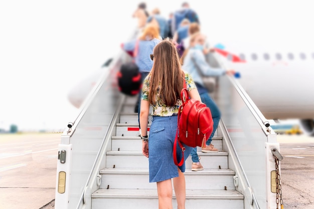 Une jeune femme marchant sur les escaliers de l'échelle à réaction d'avion se déplaçant vers les vacances