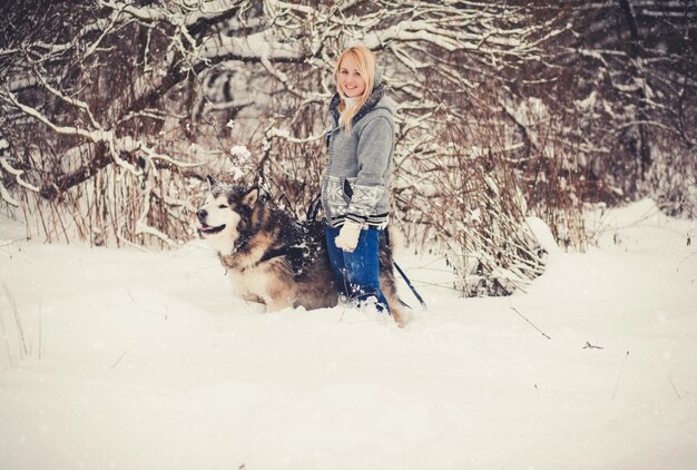 Jeune femme marchant avec un husky