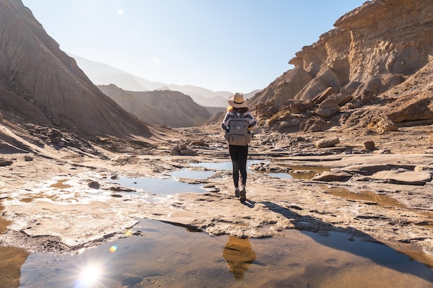 Une jeune femme marchant le long de l'eau dans le désert lors d'une randonnée sur la Rambla Las Salinas dans le désert de Tabernas, province d'AlmerÃƒÂƒÃ'Âa, Andalousie