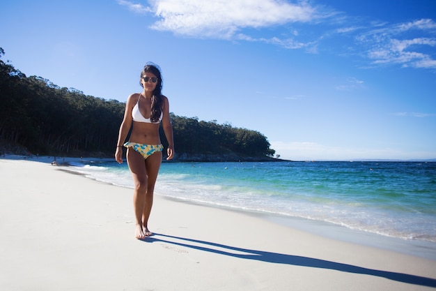 jeune femme marchant sur la plage