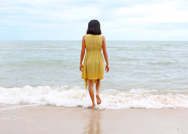 Jeune femme marchant seule sur la plage