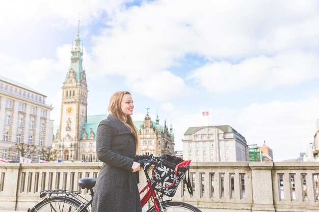 Jeune femme marchant et tenant un vélo à Hambourg
