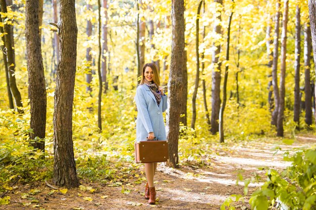 Jeune femme, marche, dans, parc automne, à, valise