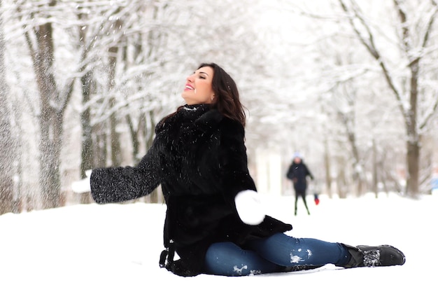 Une jeune femme marche dans un parc d'hiver en plein air